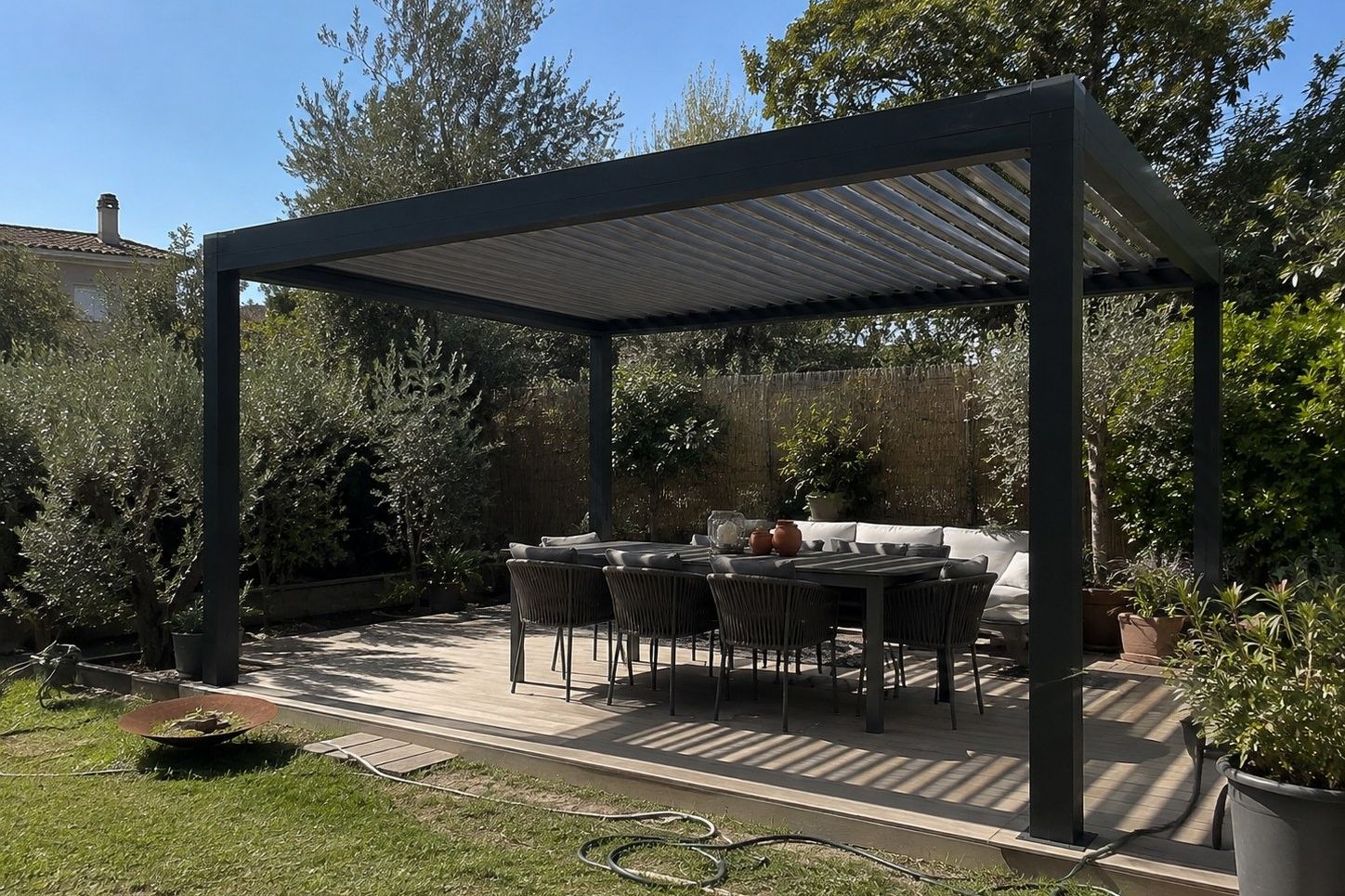 Pergola bioclimatique autoportante sur une terrasse bois : lames orientables, poutre périphérique et quatre poteaux
